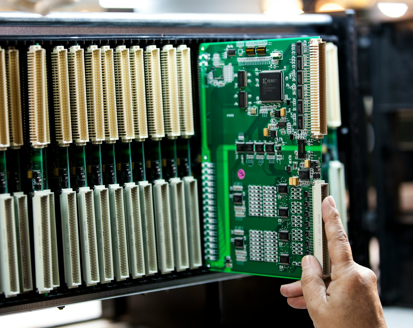 Technician installs a circuit board into a server chassis.