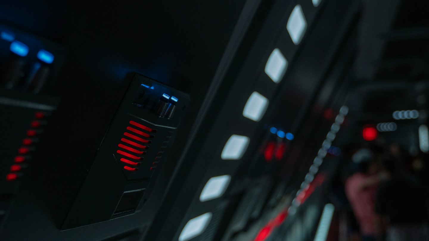 Futuristic control panel with glowing red and blue lights.
